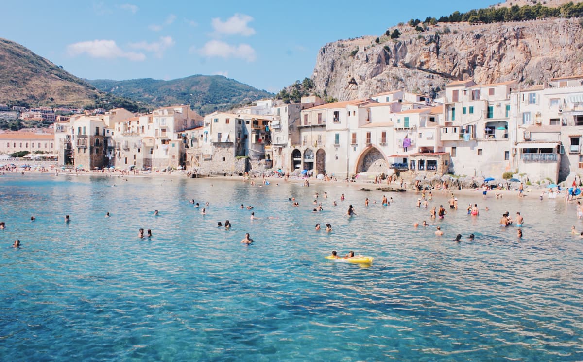 People swimming in sea by the coast